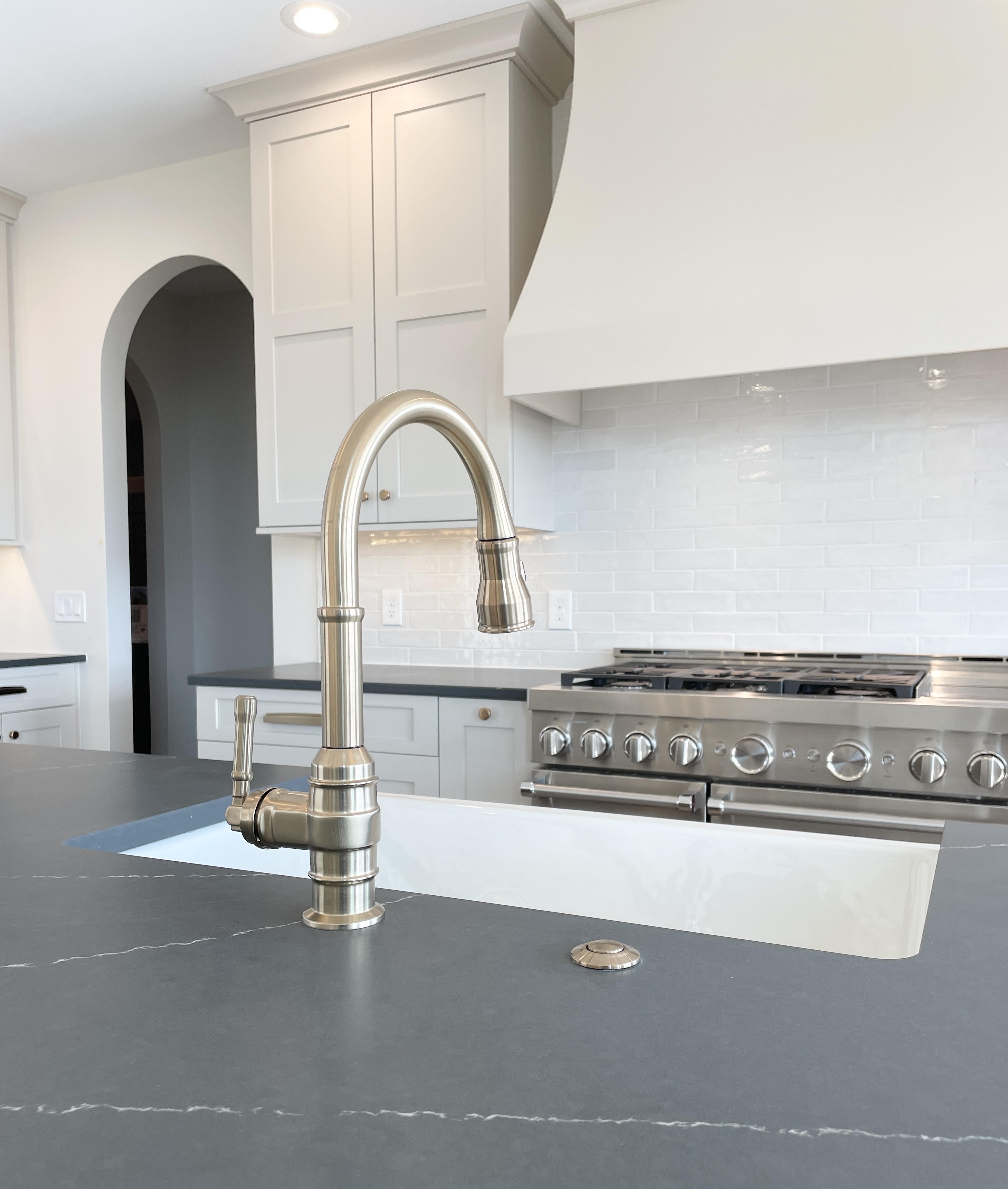 Wynnbrooke cabinetry in Accessible Beige painted finish installed with Soapstone Metropolis quartz counters in a Bettendorf, Iowa home. Kitchen by Village Home Stores for Aspen Homes of the Quad Cities.