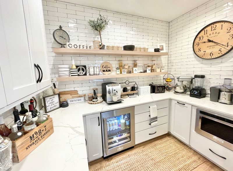 Koch Cabinetry coffee bar kitchen extension in Savannah White with White Oak floating shelves installed in a Bettendorf, Iowa kitchen by Village Home Stores for Aspen Homes of the Quad Cities.