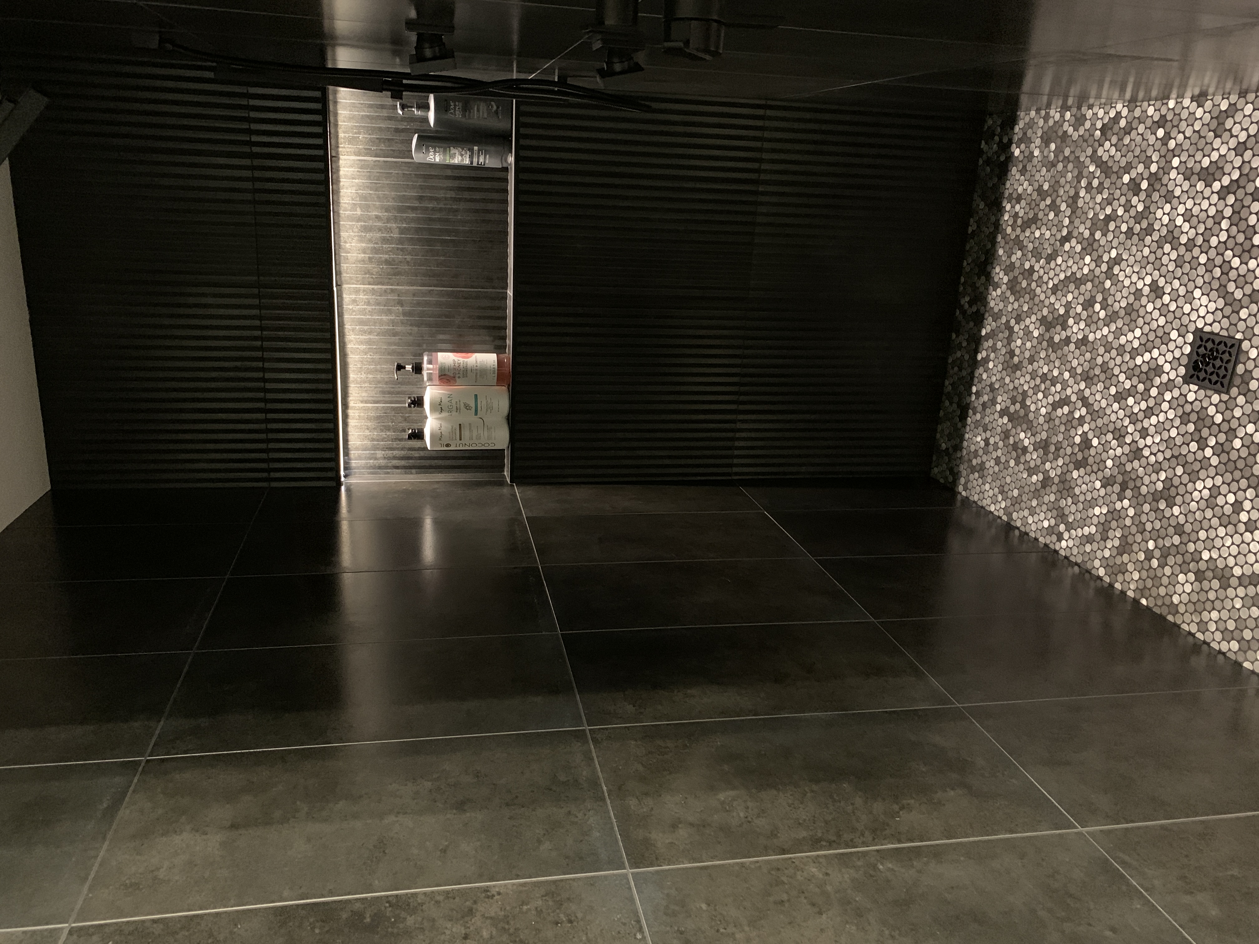 dark tiled shower with lighted shower niche