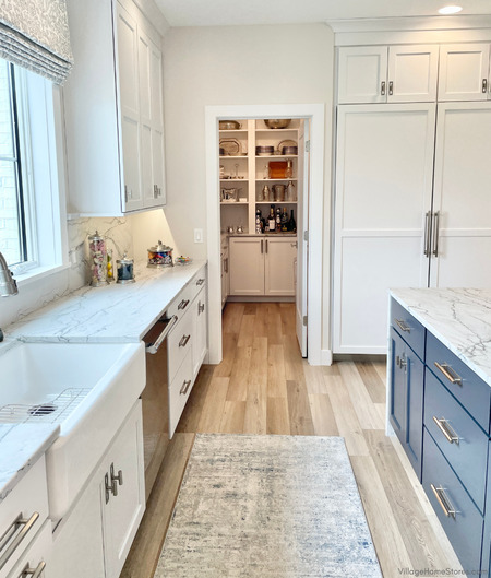 white and blue cabinet kitchen with view into walk in kitchen pantry