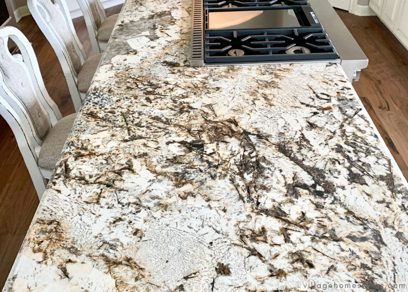 kitchen island granite countertop with slide in range and cooktop in it