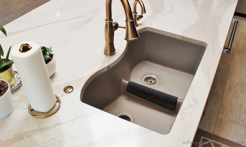 overhead view of kitchen wink with taupe low divider sink and gold kitchen faucet