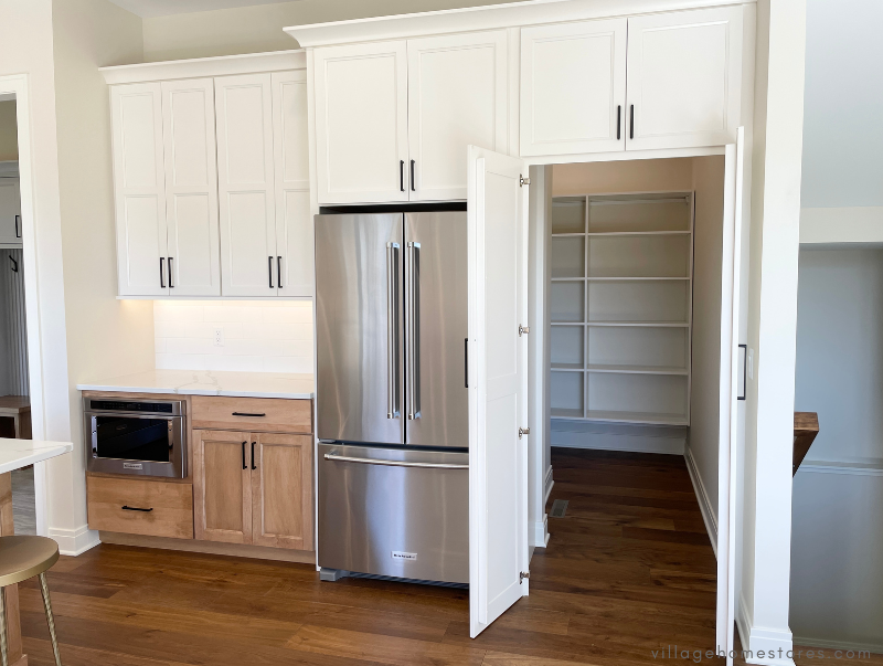 tall cabinet front doors open showing hidden pantry in kitchen