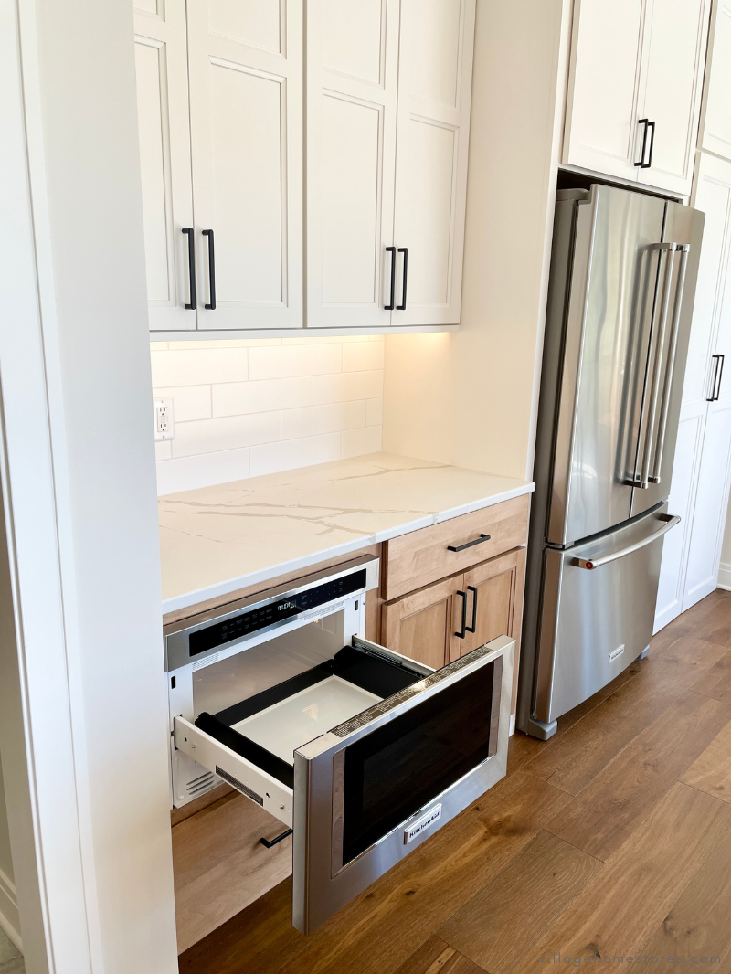 stainless steel kitchenaid refrigerator and undercounter microwave drawer shown open