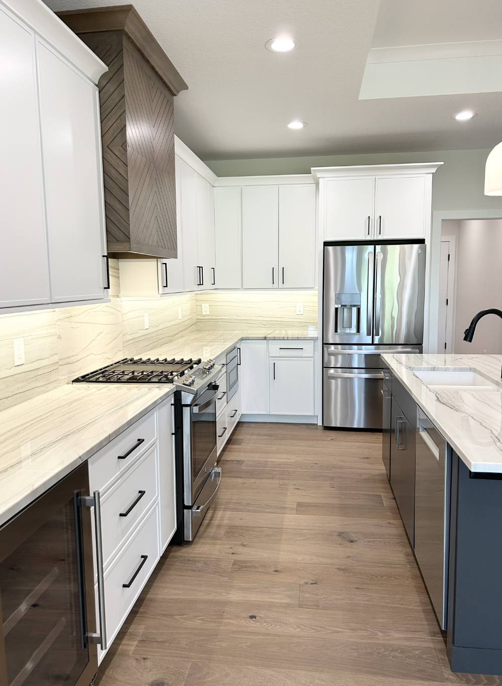 l-shaped kitchen design with light painted cabinets and dark island
