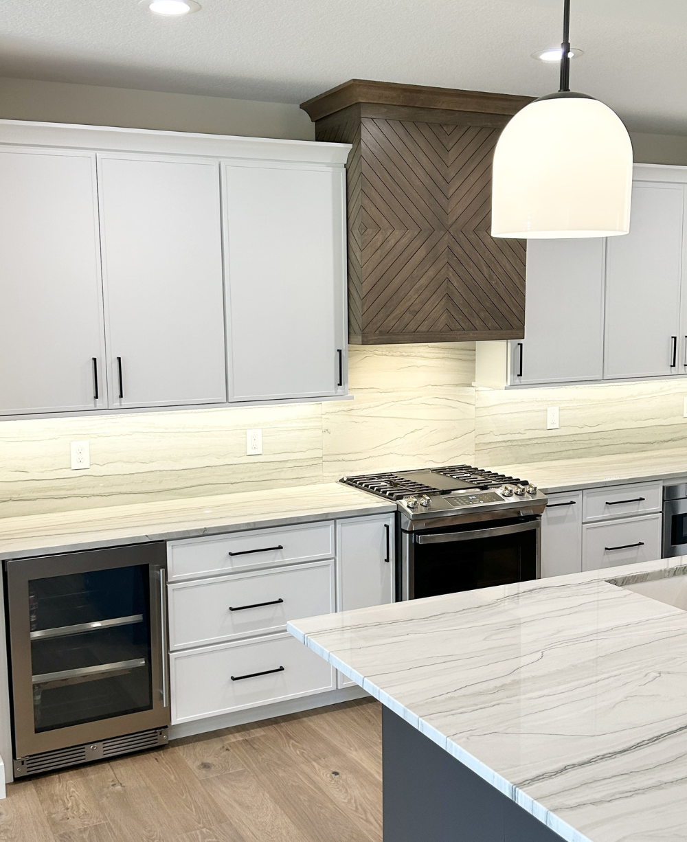painted frost white kitchen with custom design wood range hood from Advance Homes