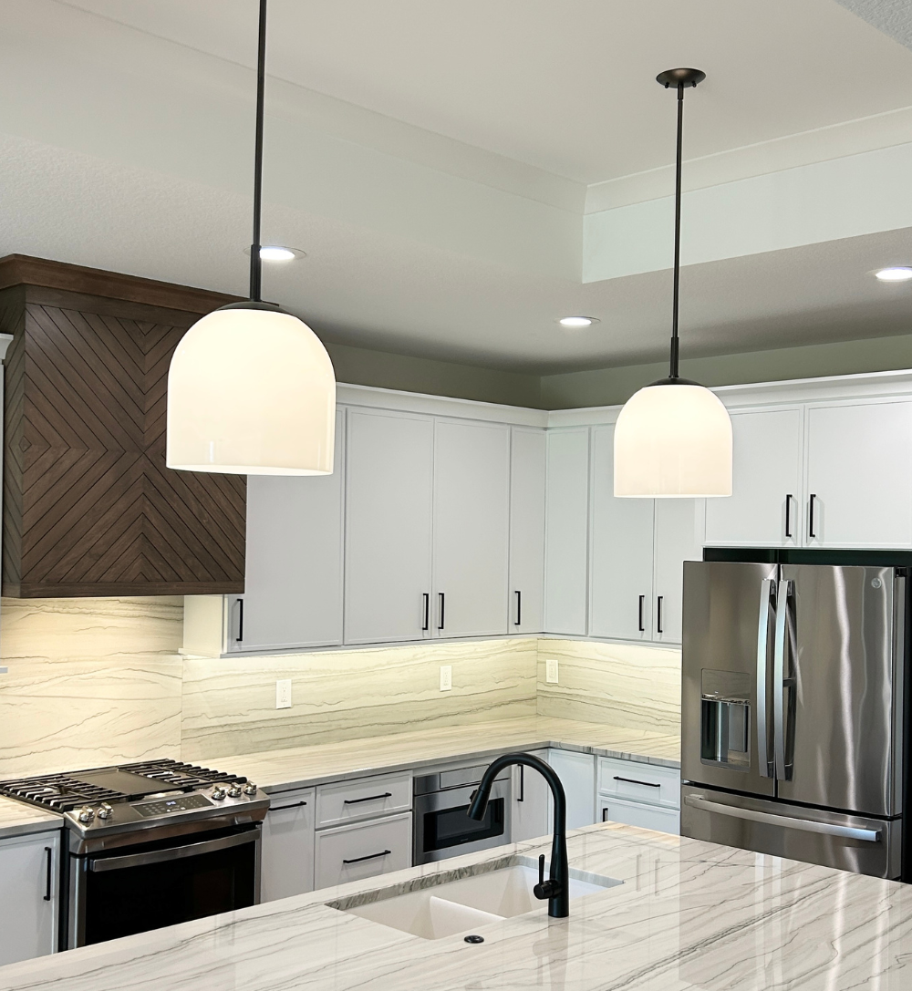 pendant lights above kitchen island with matte black poles and white glass shades