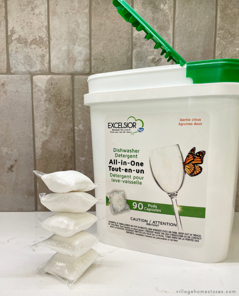 white bucket with green lid of excelsior dishwasher detergent pods with stack of five pods to left of canister