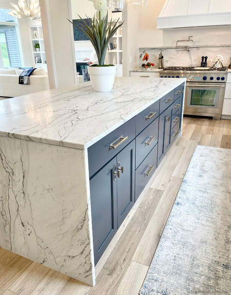 blue cabinet kitchen island in open concept kitchen design with quartzite countertops