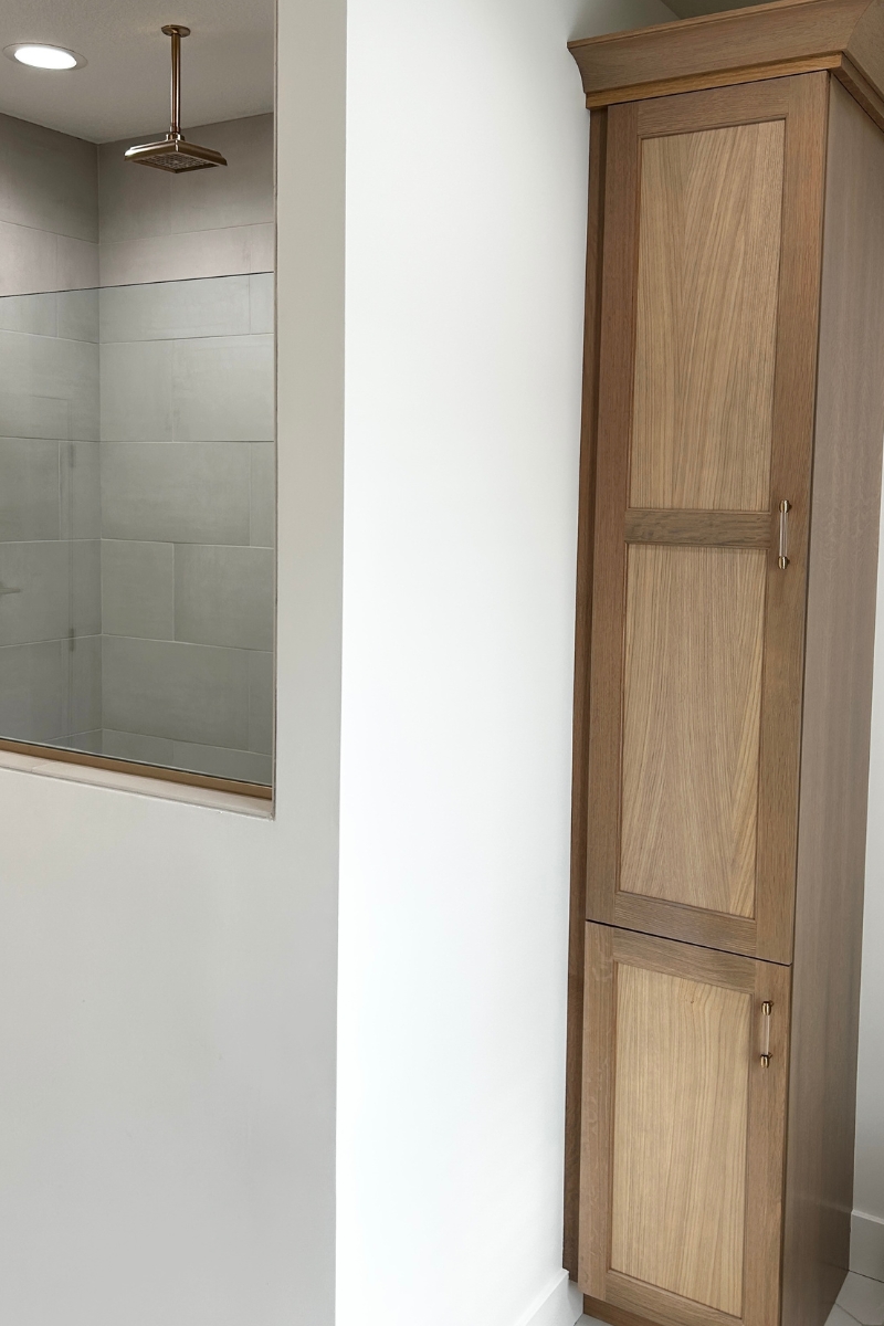 light oak tall linen cabinet in bathroom