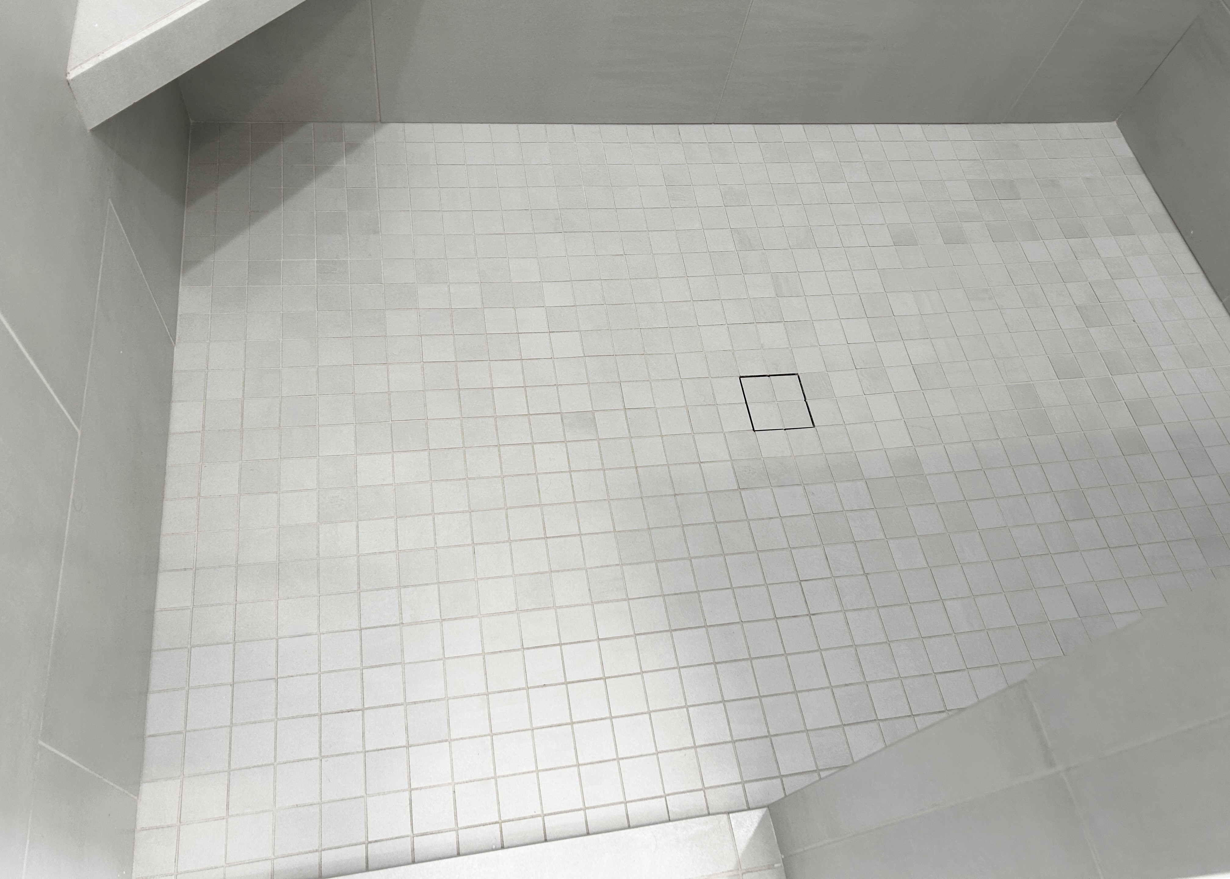 mosaic tile floor of shower with tile shower drain