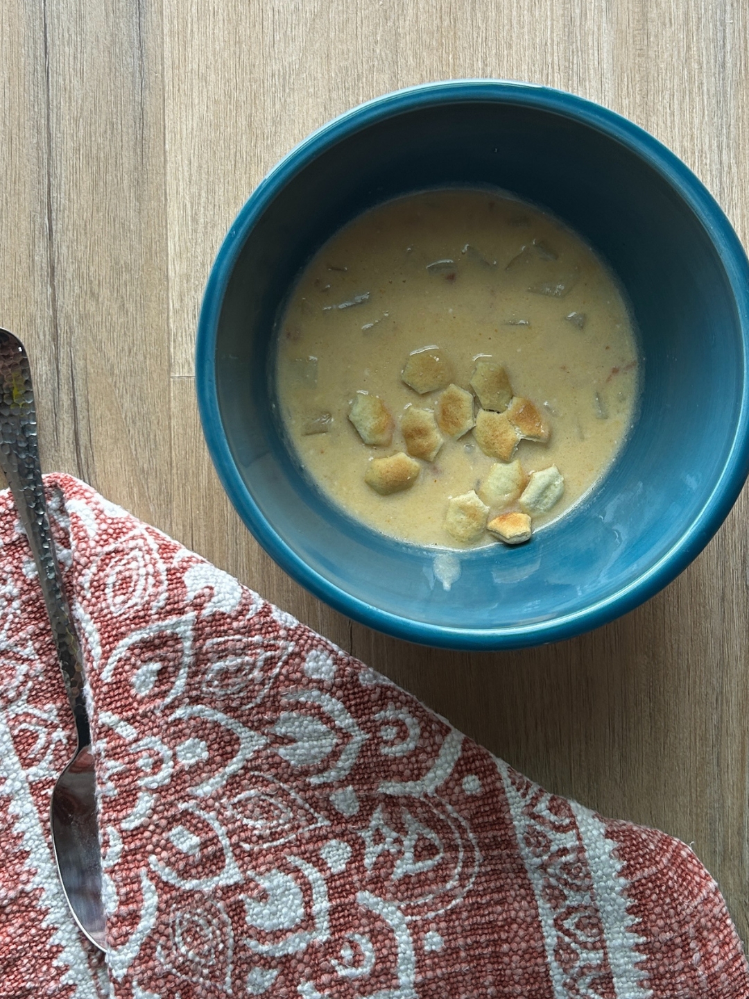 blue bowl with crock pot potato soup and soup crackers in it