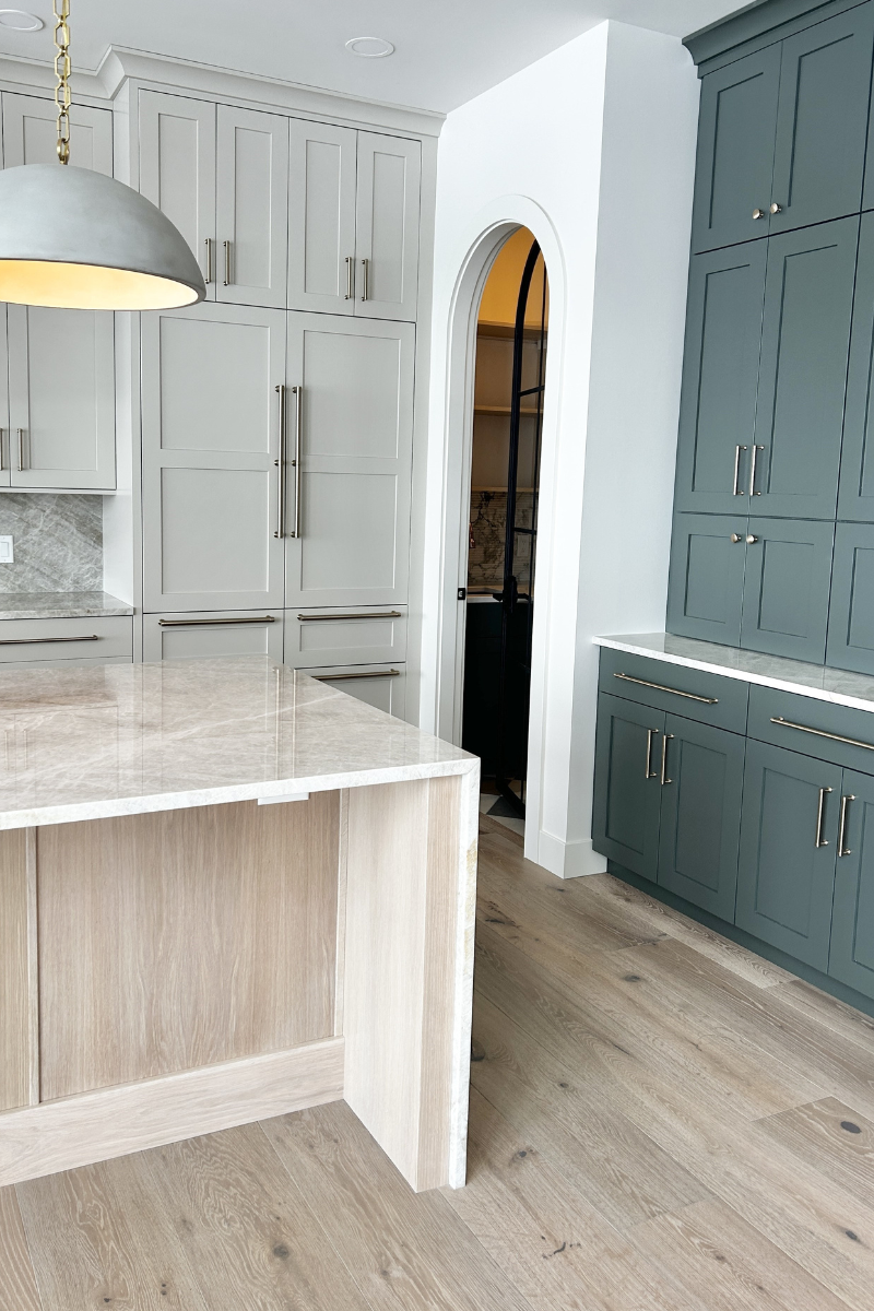 kitchen cabinets in a quad cities home with accessible beige white oak sand and shade grown green painted cabinets shown