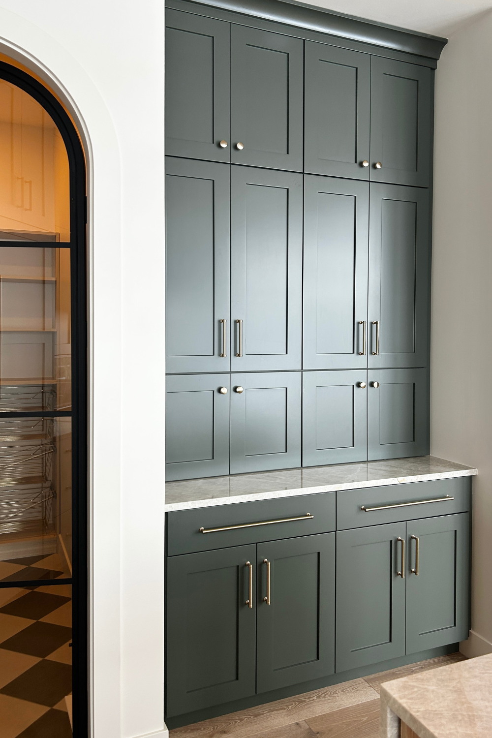 shade grown green painted cabinetry in kitchen with wall to wall appliance garages