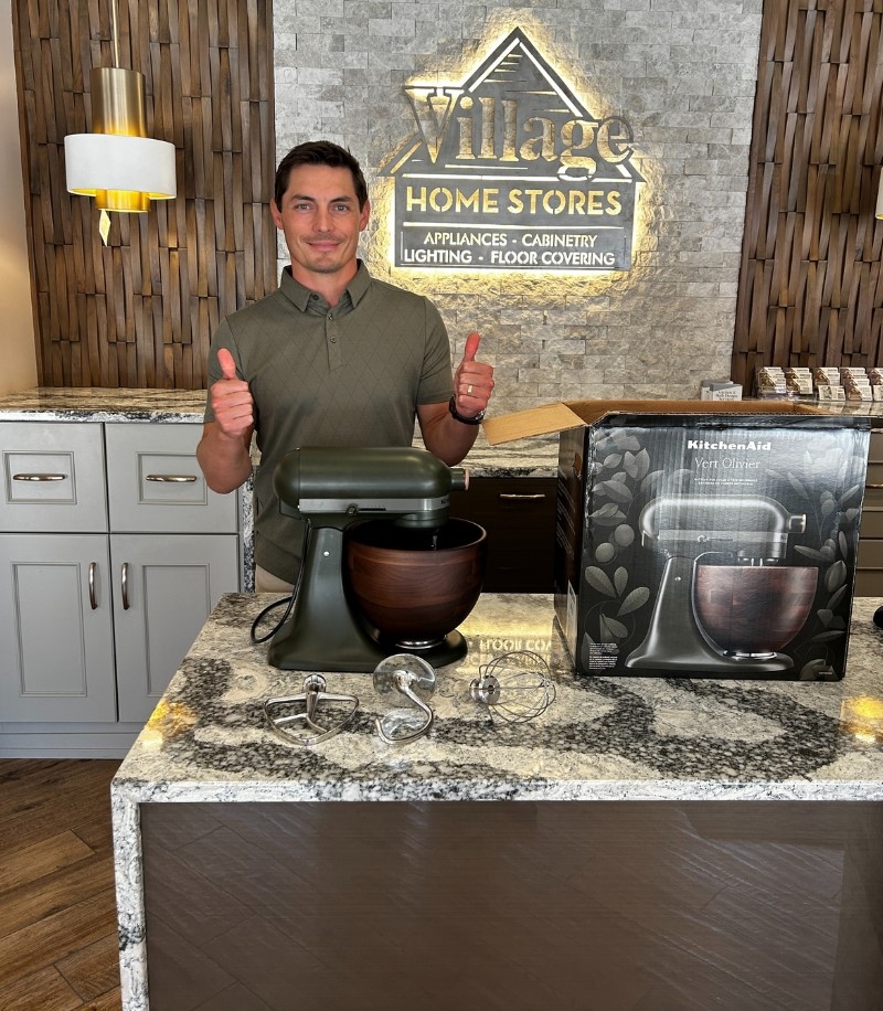 village home stores owner collin akers with kitchenaid stand mixer with wood bowl for event giveaway