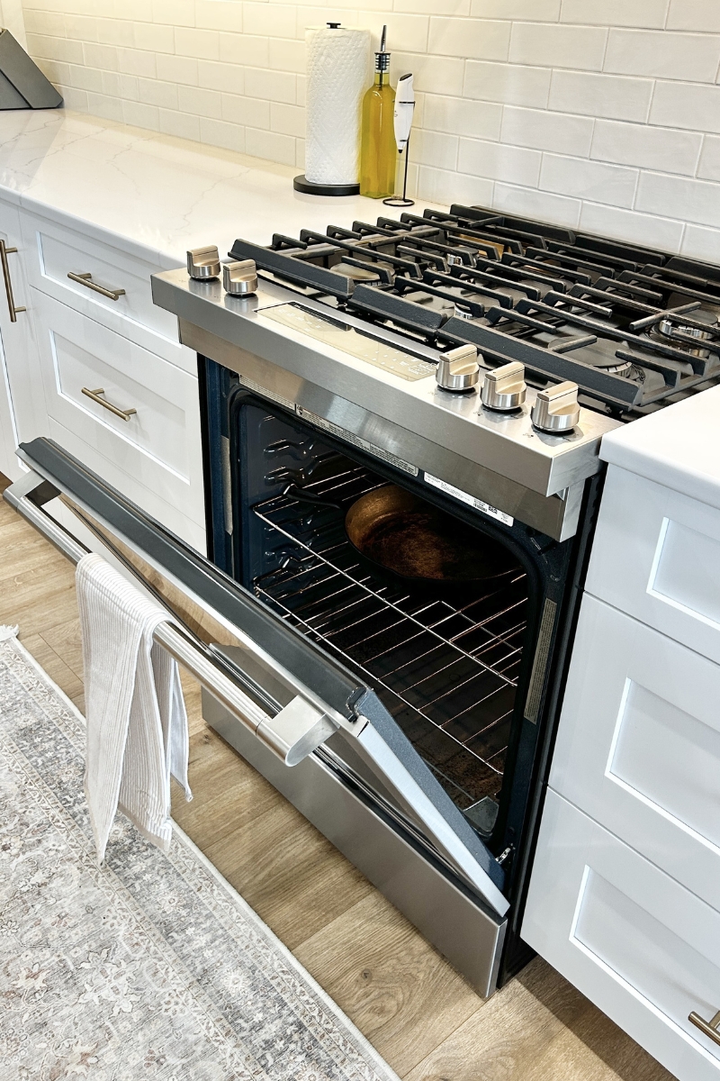 maytag gas range in stainless steel shown with door open and cast iron pan inside oven