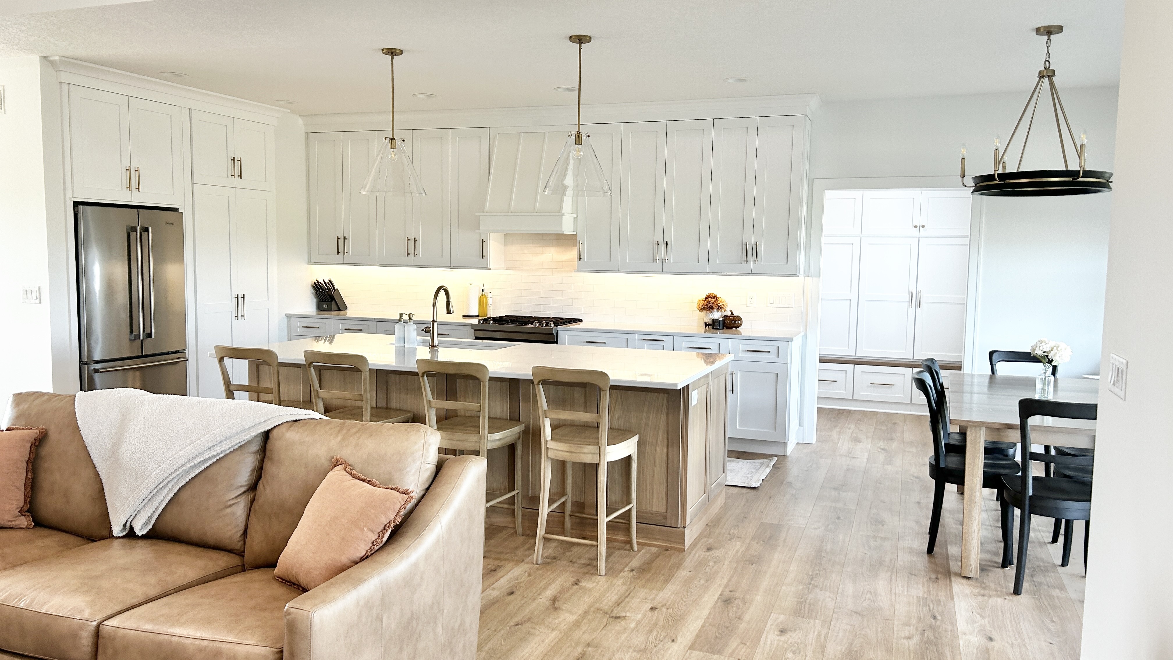wide shot of open concept kitchen design by village home stores with great room and dining room nearby