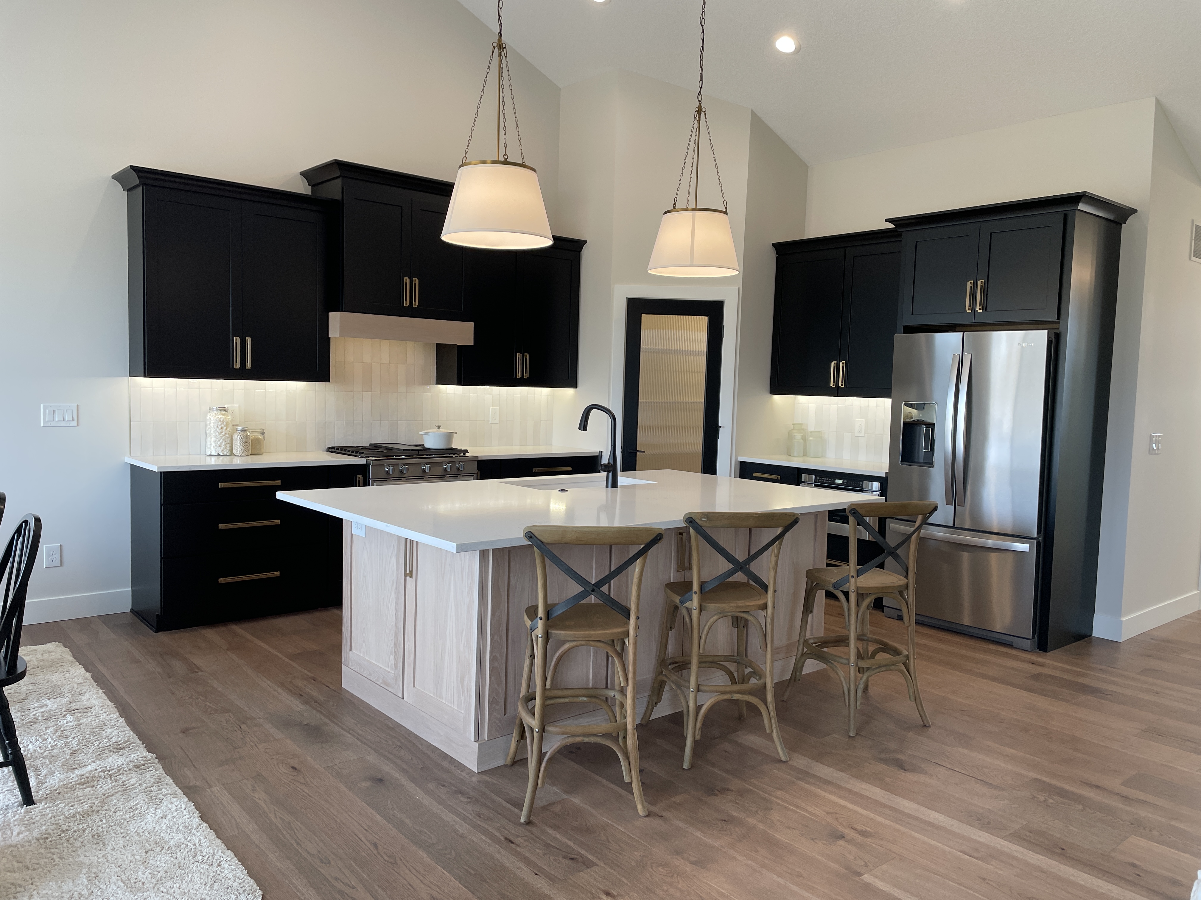 kitchen design by advance homes quad cities with black and white oak cabinets and seating at the island