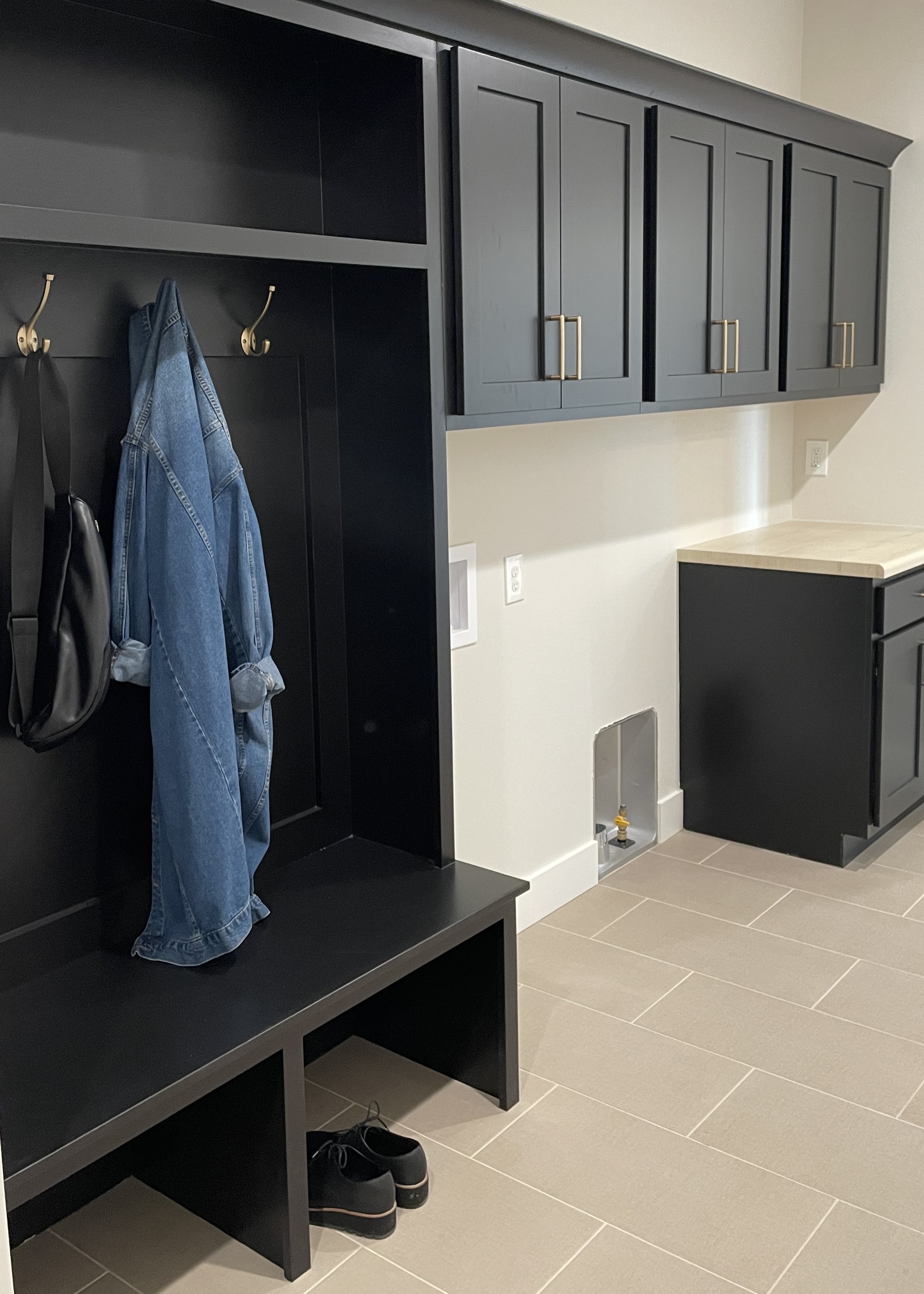 laundry room cabinets with bench dropzone area and denim coat on coathanger