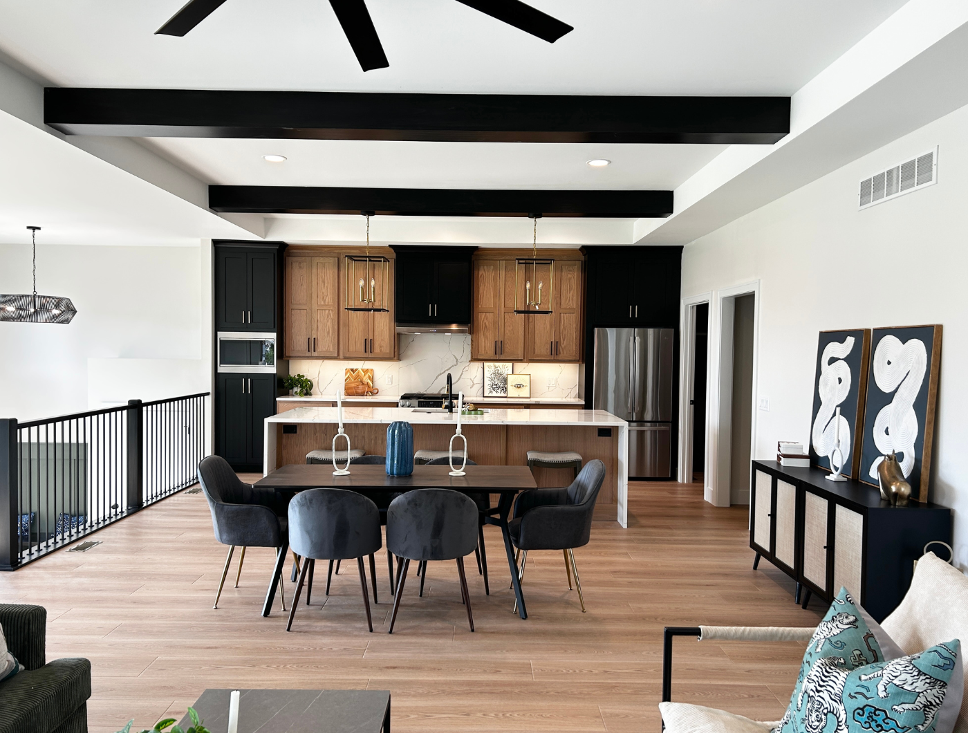 great room kitchen design with dark beam ceiling and white oak and black cabinet finishes