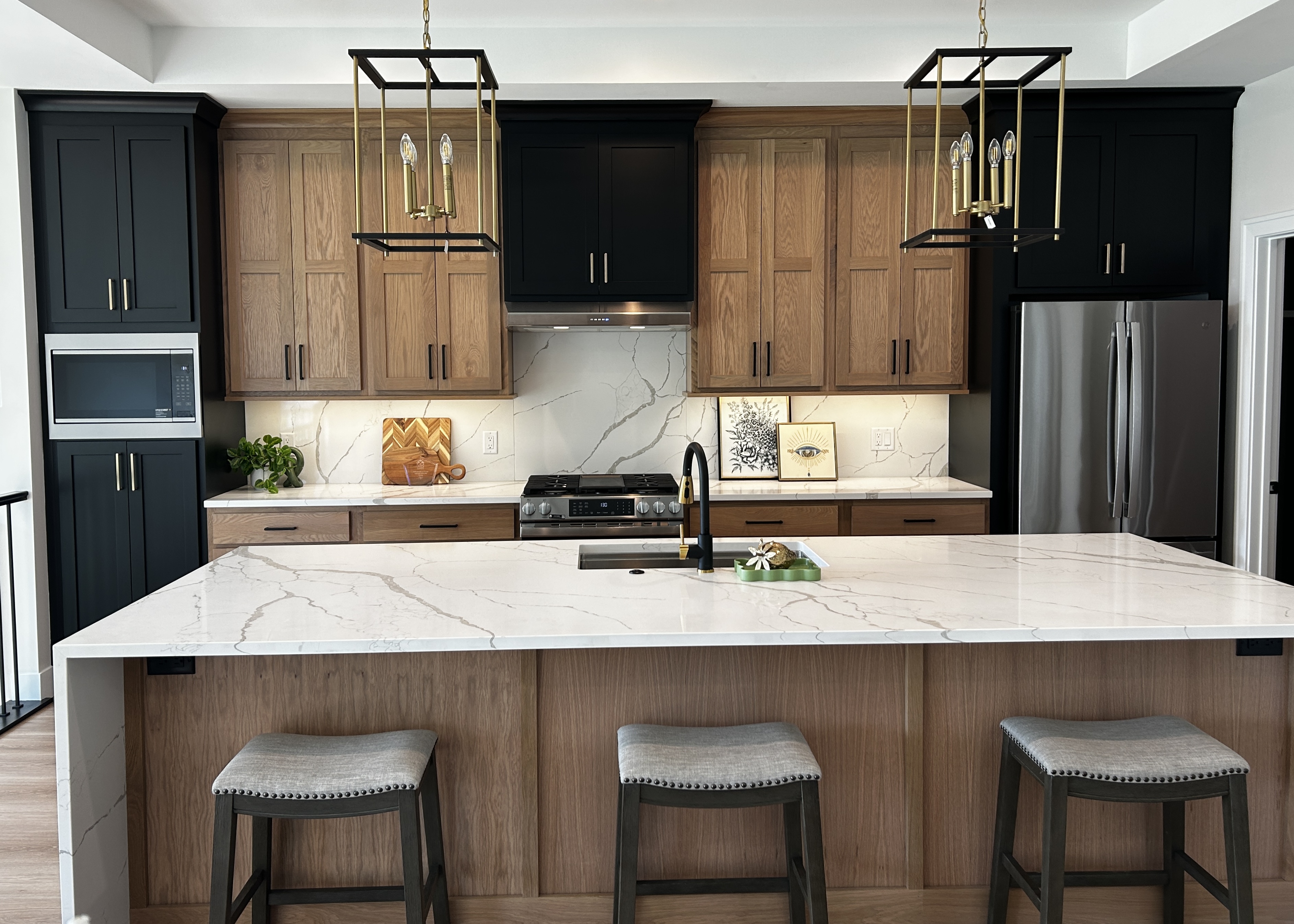 Koch cabinets in white oak wheat stain with black painted cabinet accents from Village Home Stores