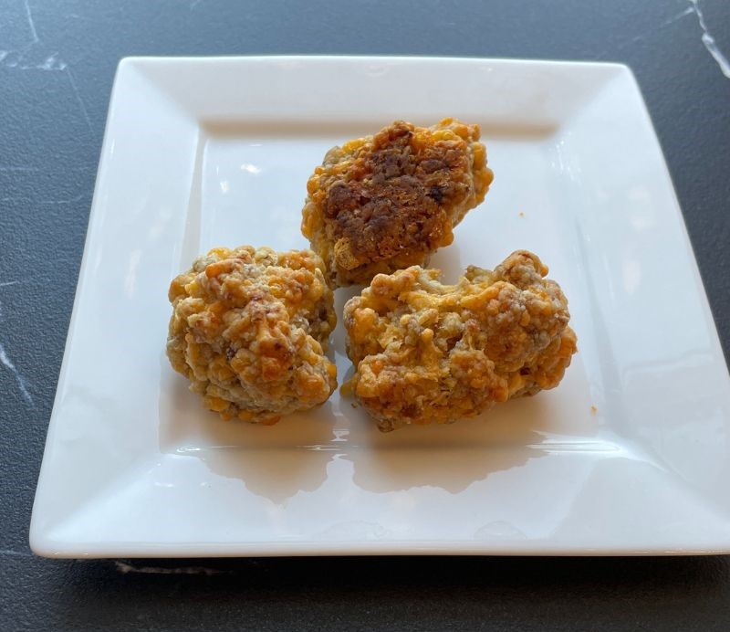 white square plate with three cheddar bay sausage biscuits on it