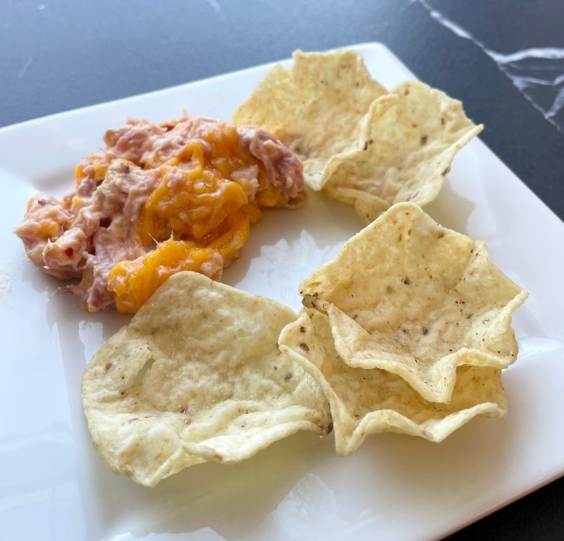 white plate with pulled pork dip and tortilla chips