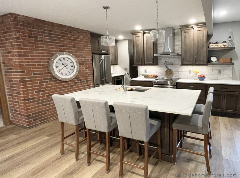 kitchen with brick wall grey cabinets and large kitchen island at the center