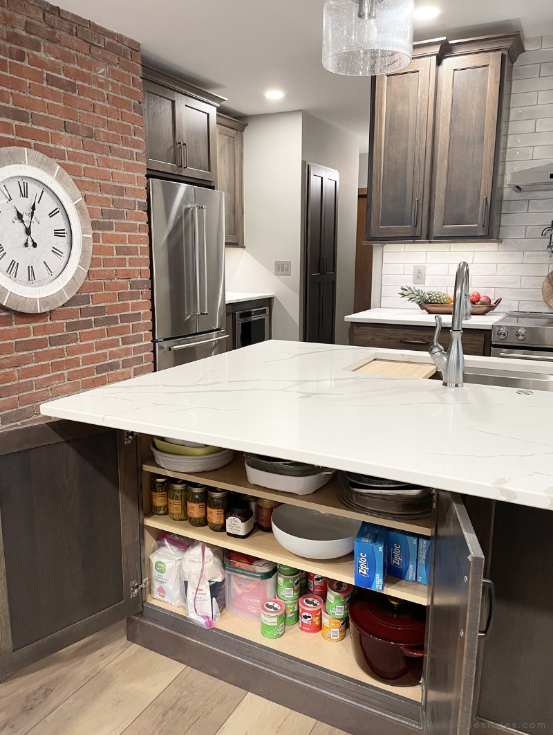 back of kitchen island showing doors open underneath overhang for added storage