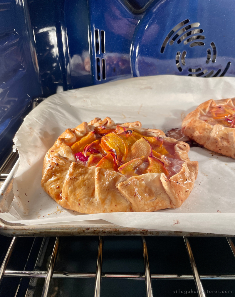 pair of fruit pastries baking in oven with blue interior