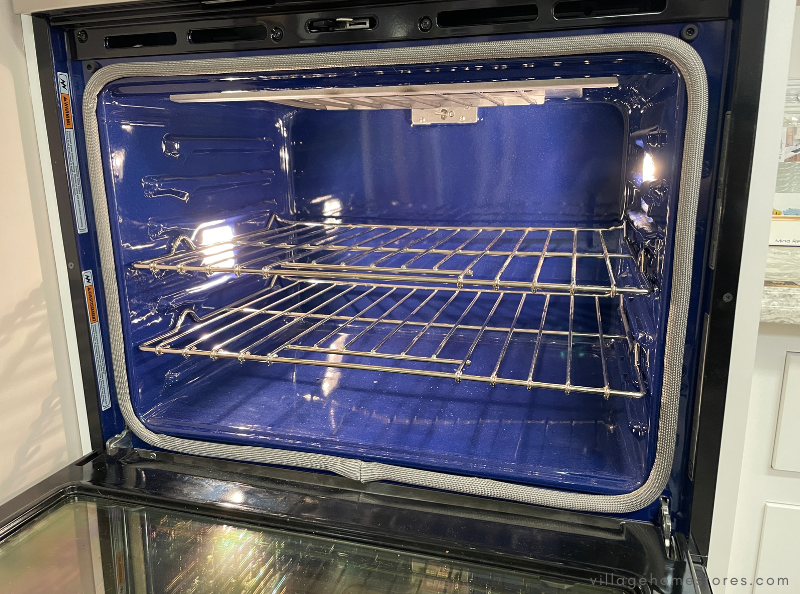 conventional oven interior with door open showing racks and blue interior