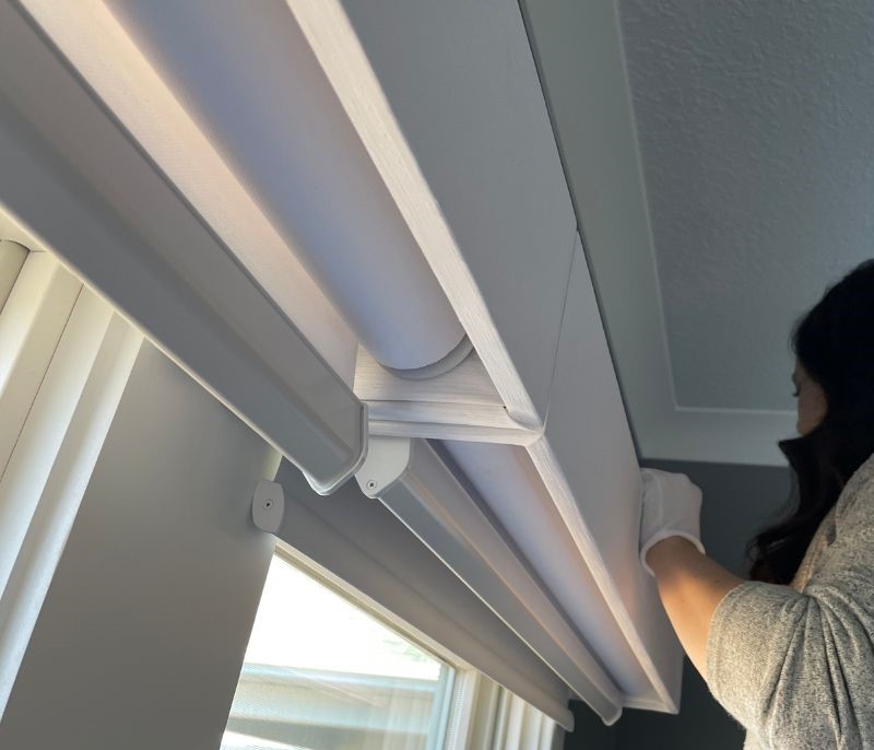 a look under and behind the valance showing dual shade layers of transitions and blackout rollers