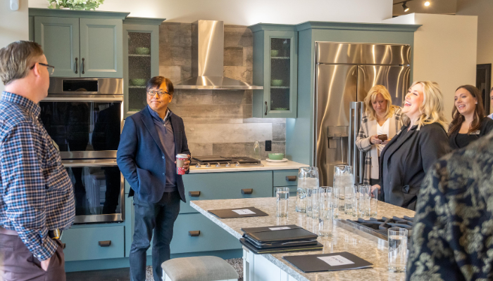 The sales team at Bekins speaking with Sam Kim, president of LG's Home Appliances, in their showroom