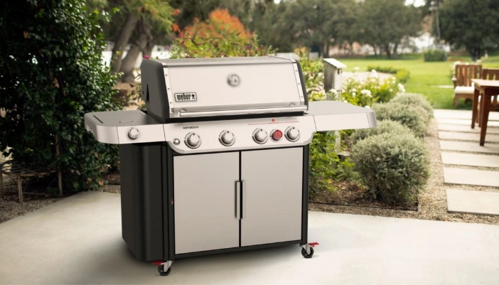 A grill sits prominently in a backyard.