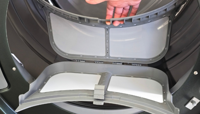 A closeup of a hand removing a dryer vent.