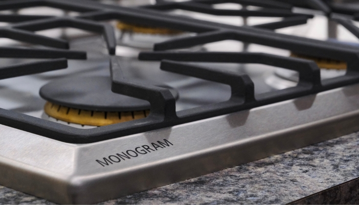A closeup of a Monogram gas cooktop.