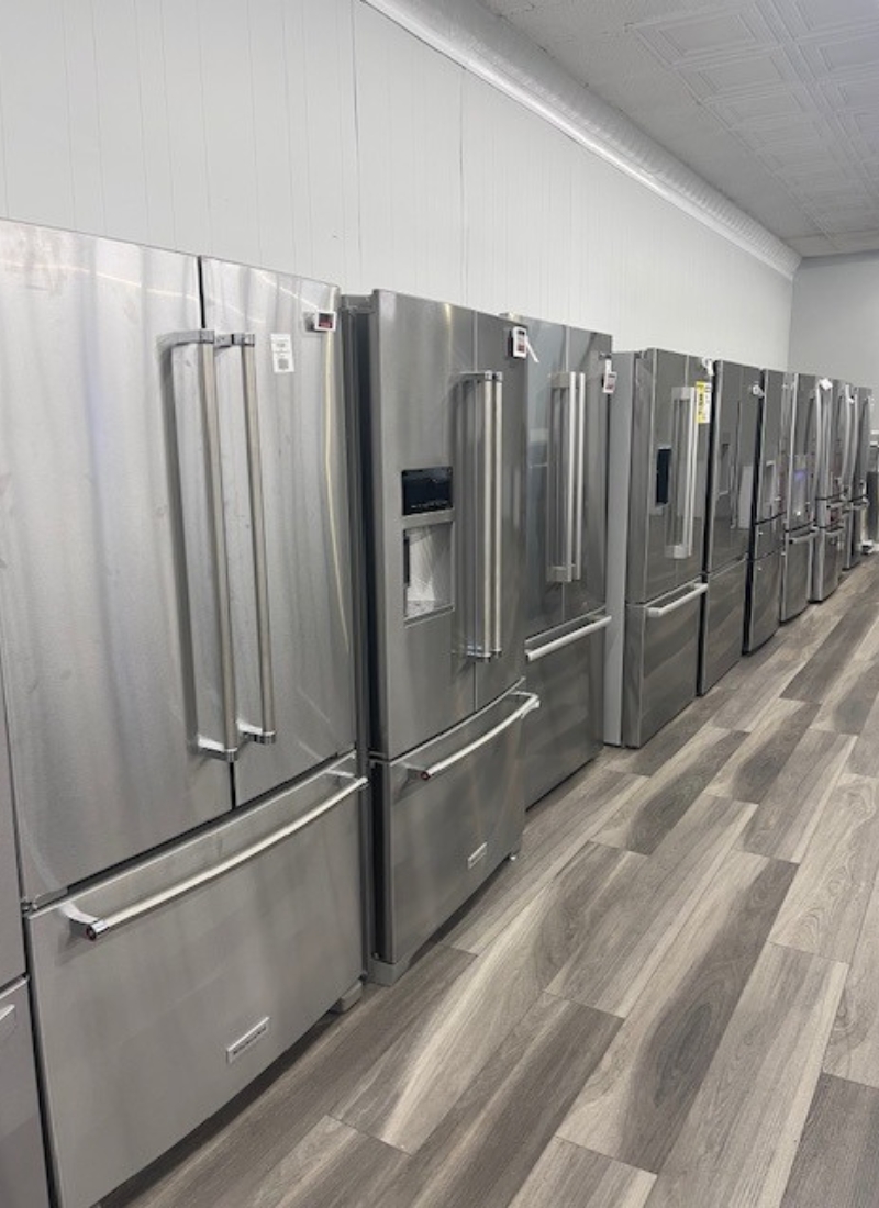A showroom of refrigerators in a row.