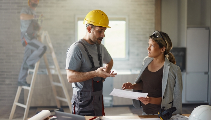 A planner and a contractor work together to plan out a kitchen remodel.