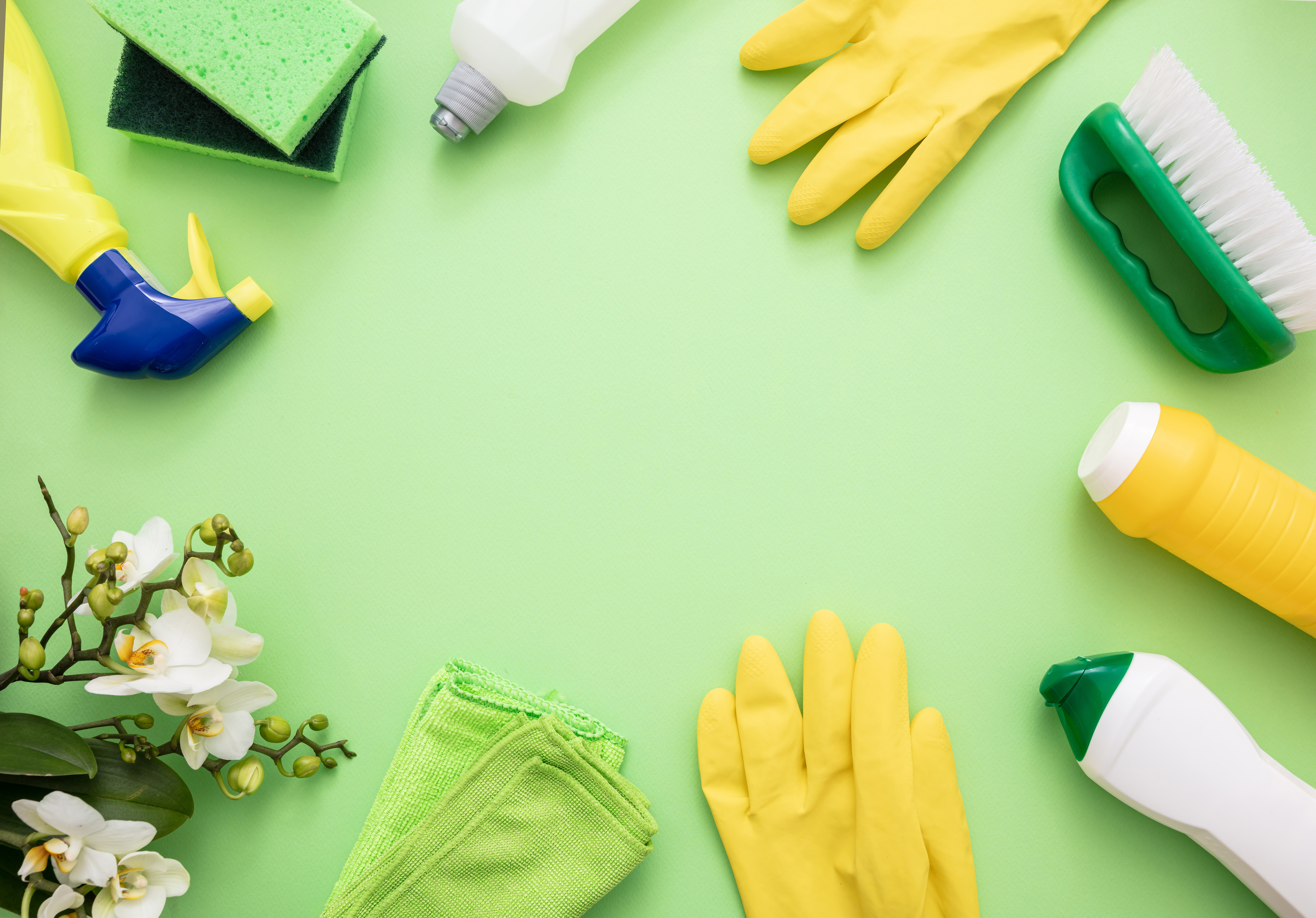An assortment of cleaning materials on a bright green background 