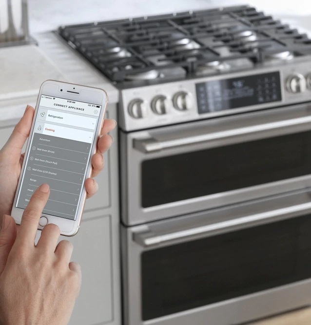 Woman using Chef Connect App on Cafe CGS700P2MS1 gas range