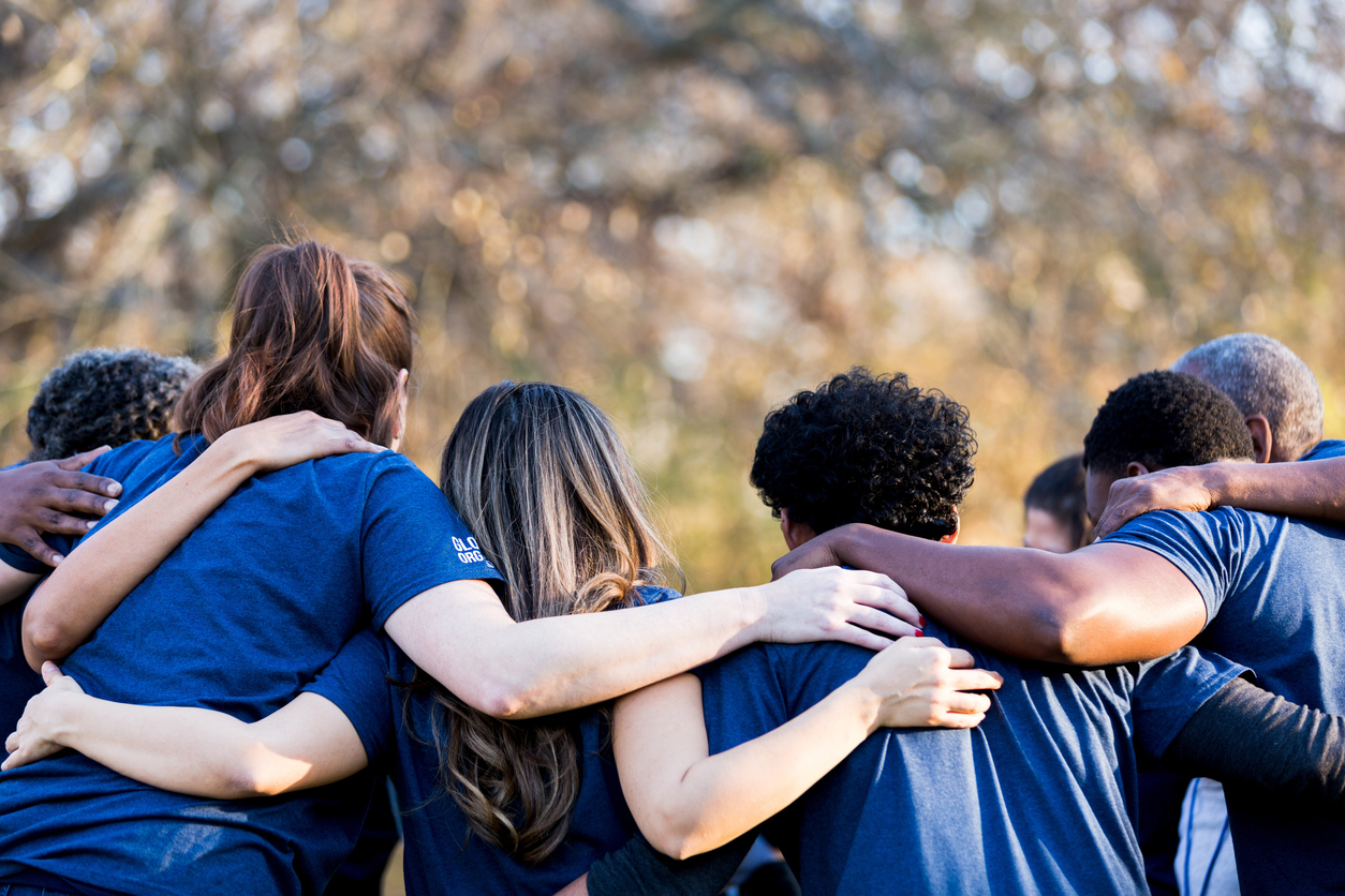 group of people in blue shirts huddled together