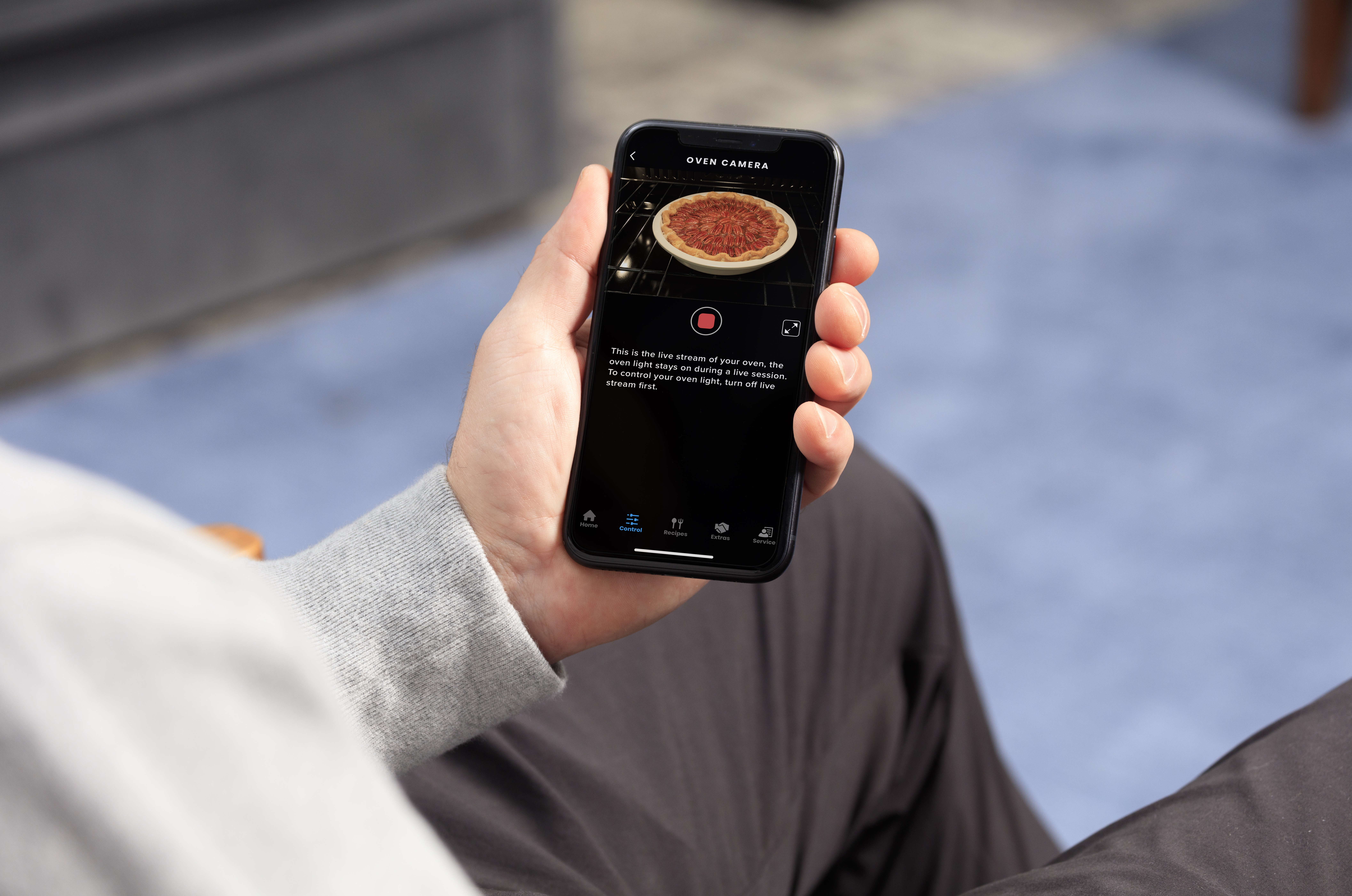 man monitoring pizza on phone using ge oven camera feature 