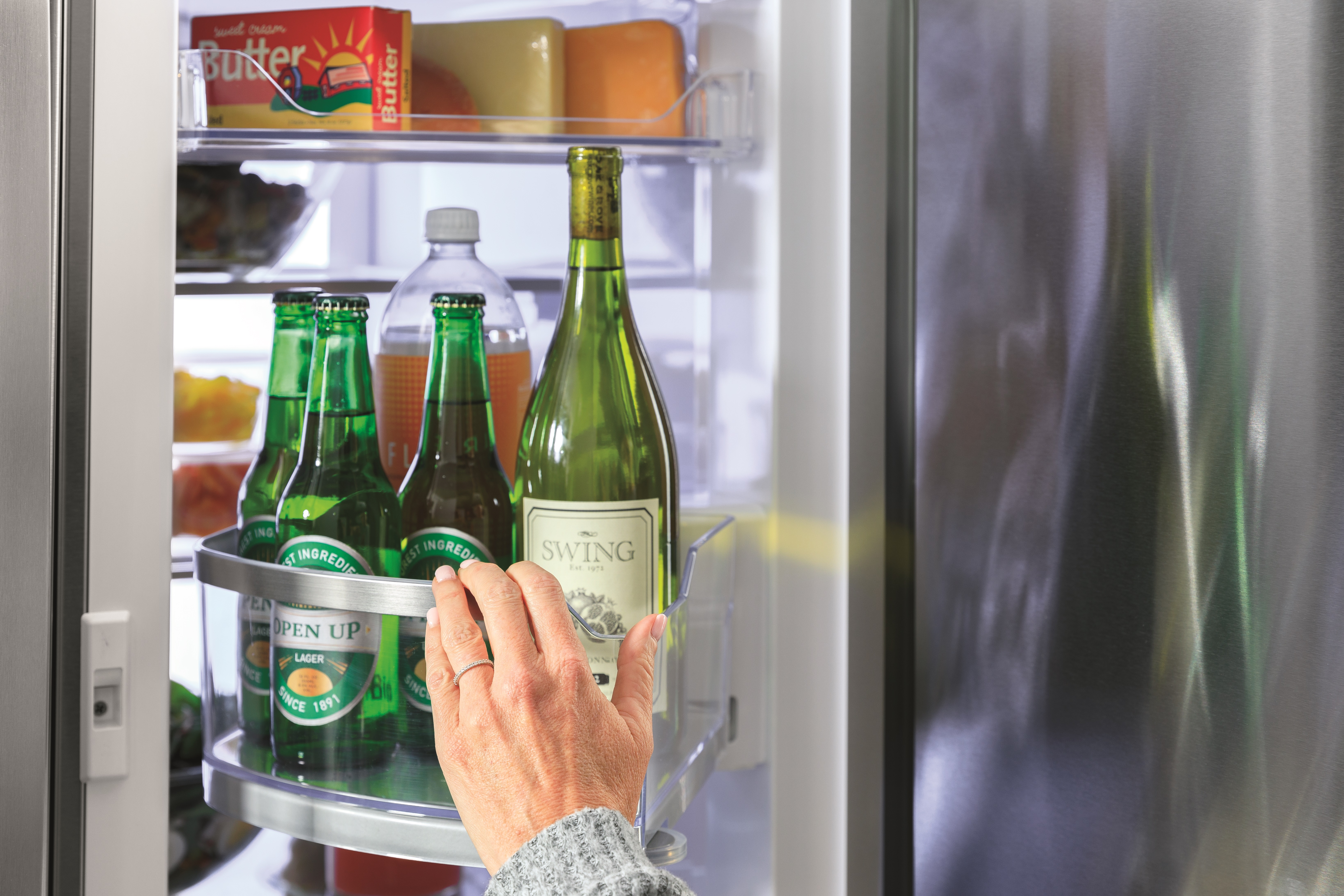 person using the rotating door-in-door bins on ge profile PVD28BYNFS refrigerator