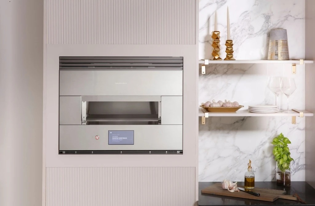 Monogram ZEP30FRSS 30” Smart Hearth Oven installed into beige cabinetry next to a marble wall 