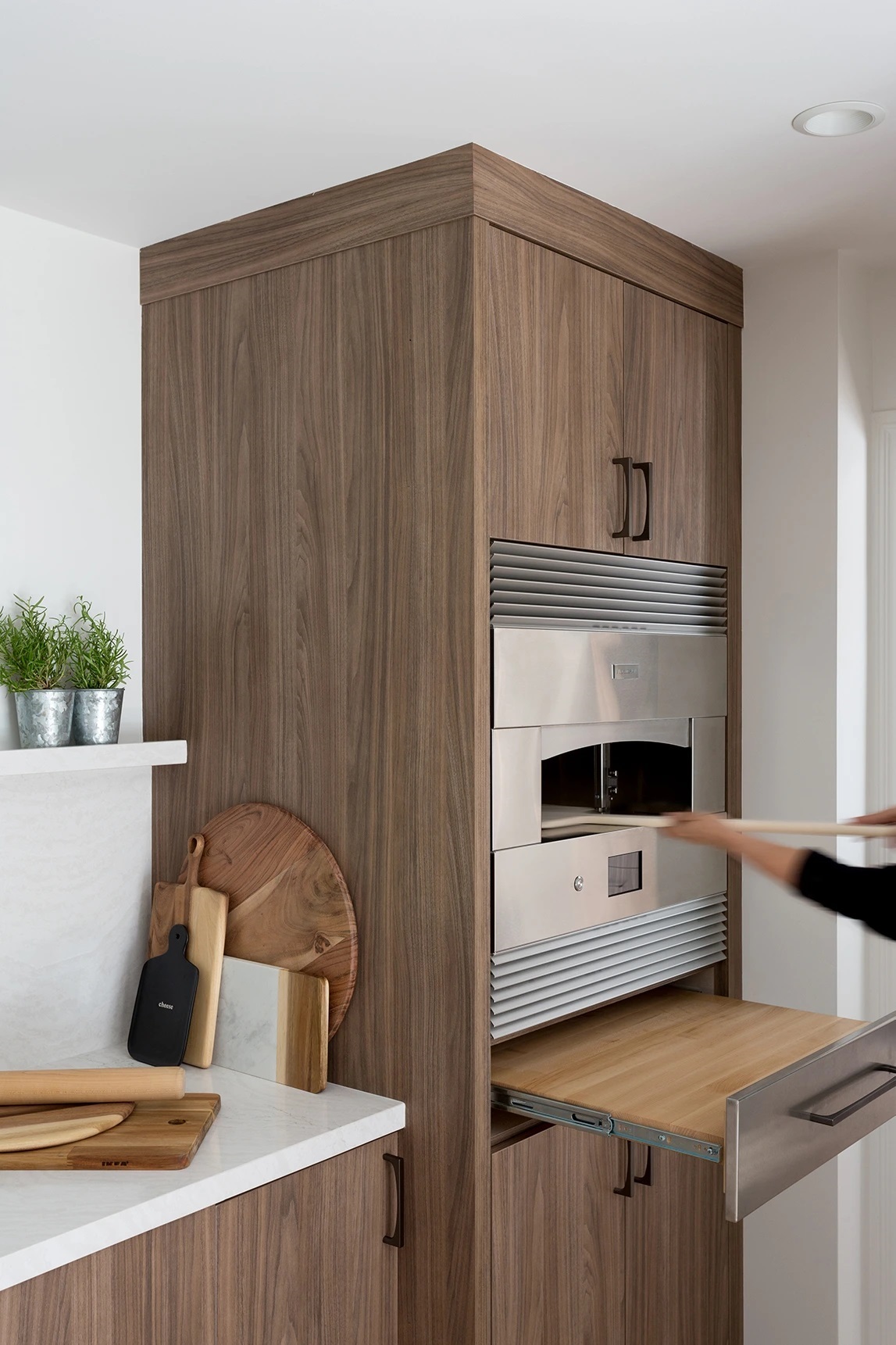 Four Point Monogram kitchen design featuring the owner taking a pizza out of a Monogram hearth oven 