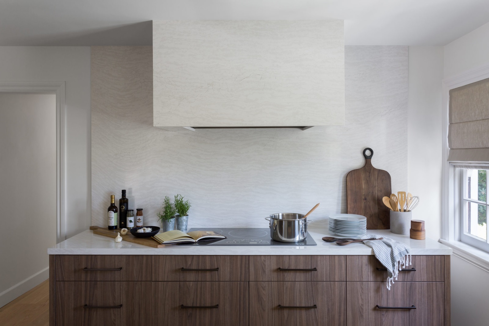 Four Point Design kitchen featuring Monogram induction cooktop and hidden vent