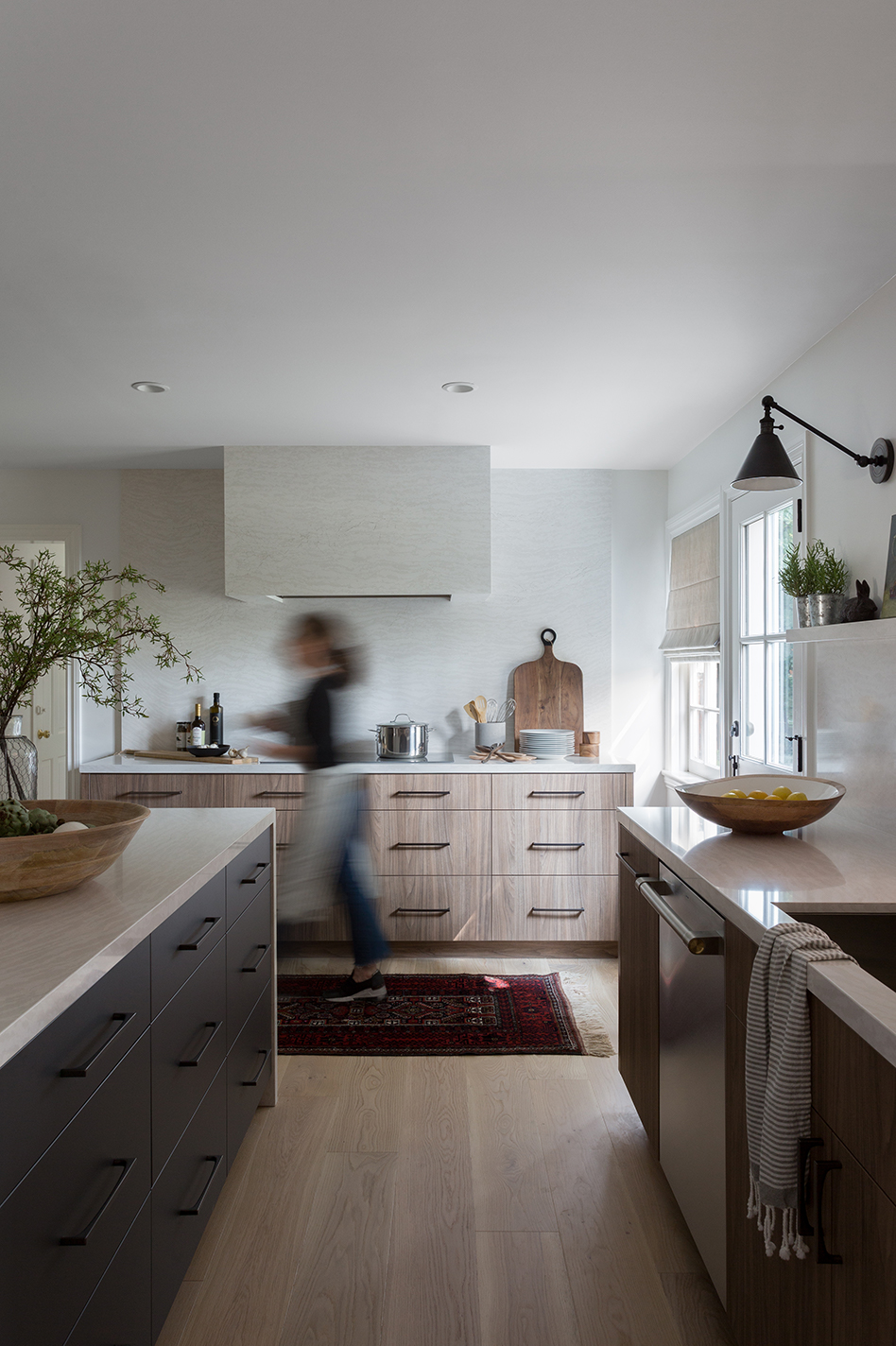 Woman walks by in Four Point kitchen featuring monogram ZDWR240NBS dishwasher