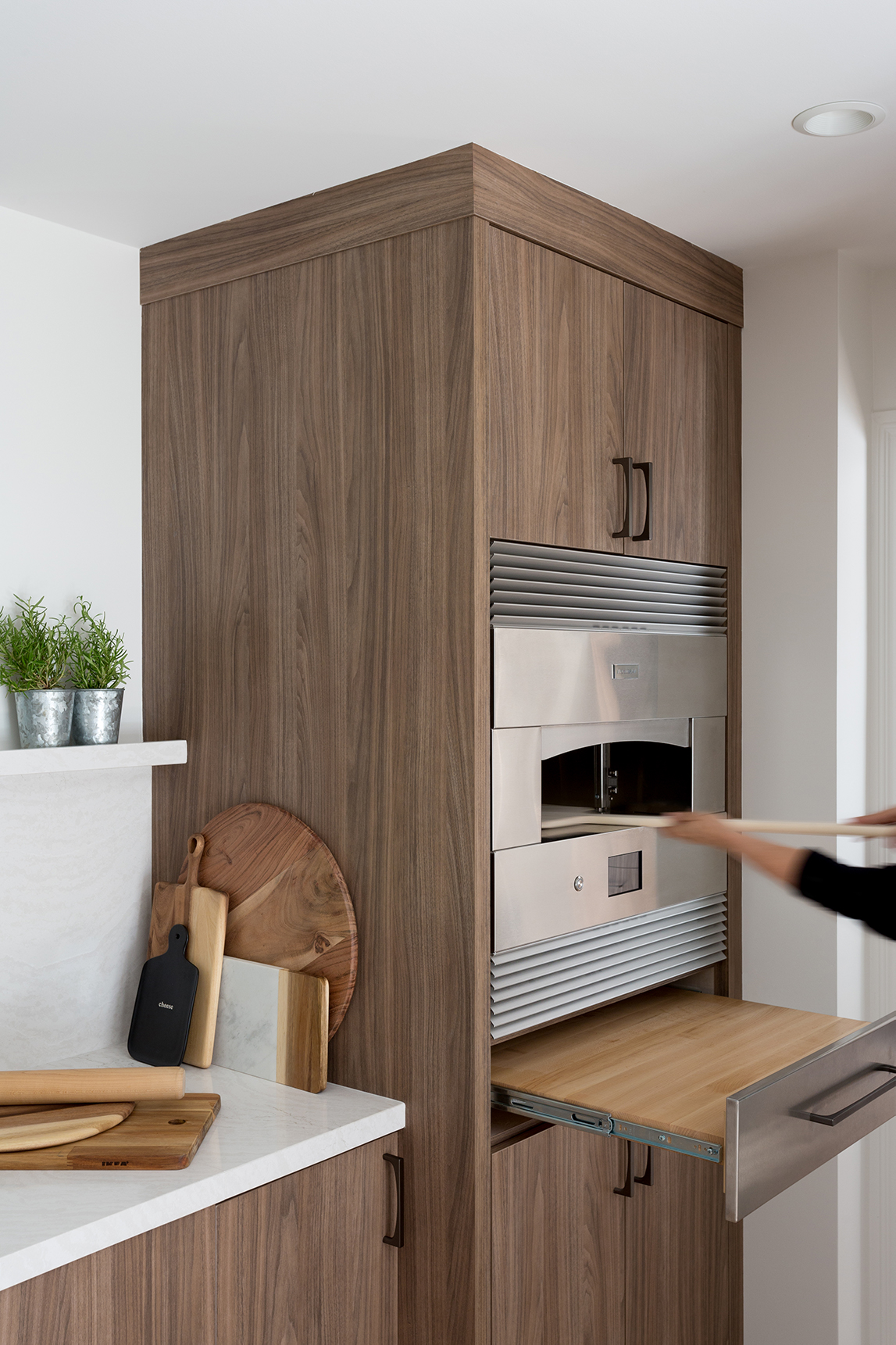 woman uses a pizza peel to remove item from monogram ZEP30SKSS hearth oven