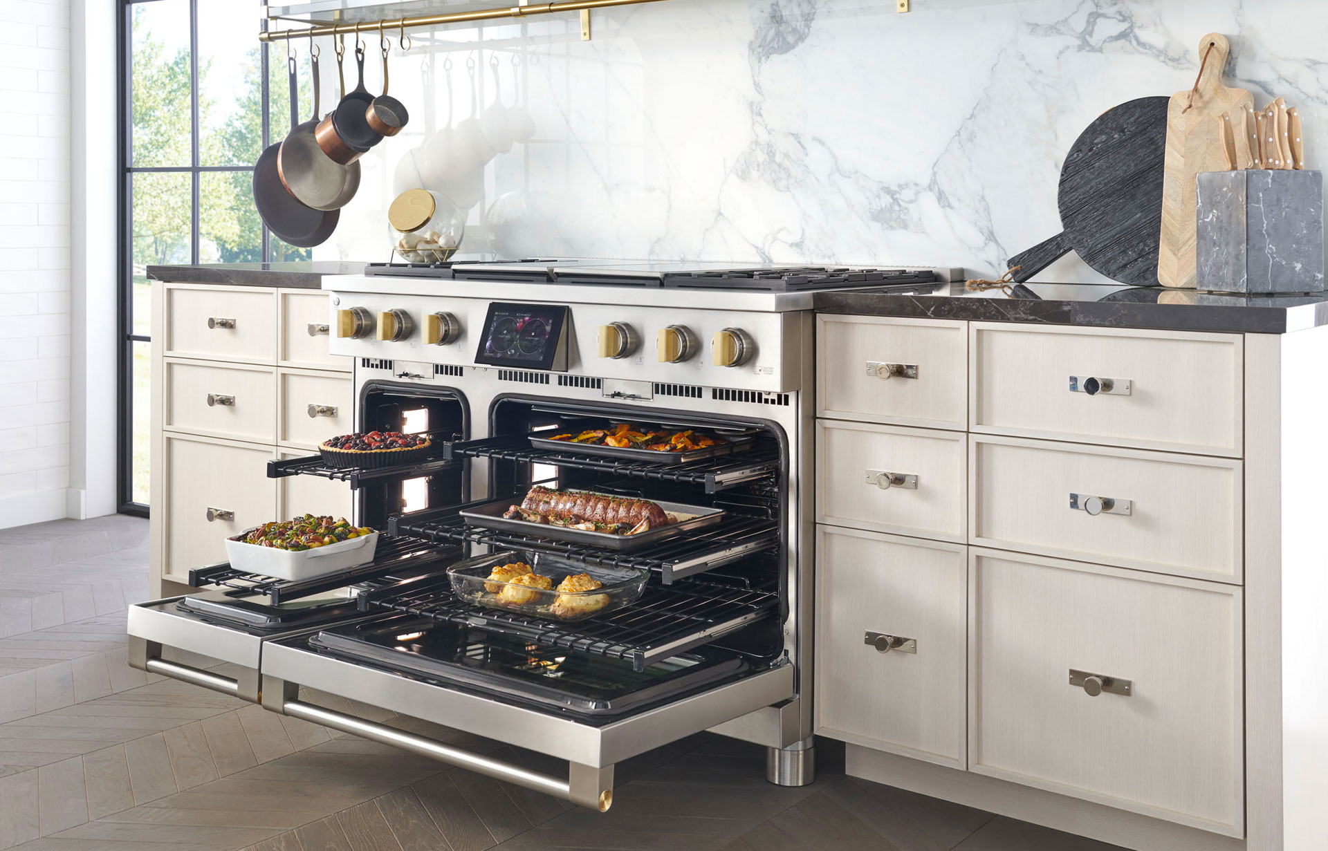 Wide shot of Monogram 48-inch professional range with ovens open and full menu of items