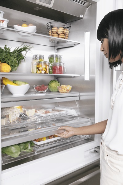 Woman surveying food items inside Thermador refrigerator